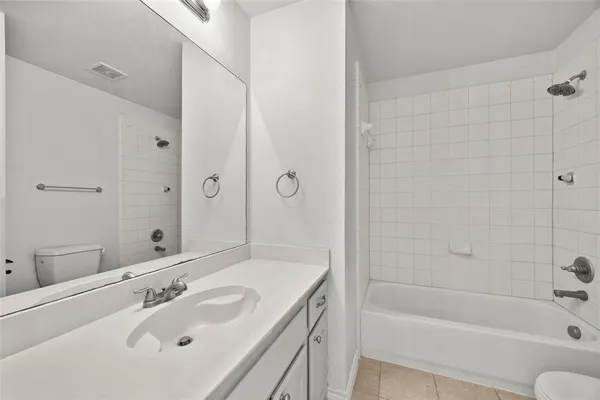 a bathroom with a tub shower sink and mirror