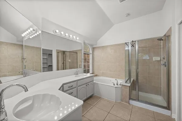 a bathroom with a double vanity sink a toilet a mirror and shower