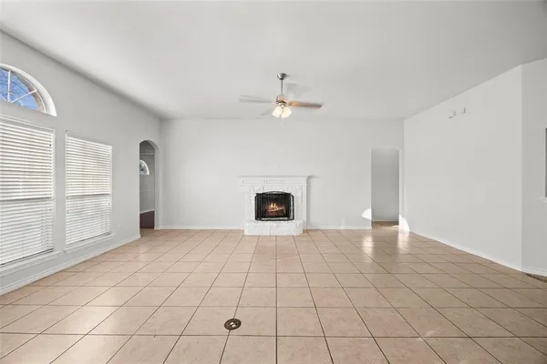 an empty room with windows and fireplace
