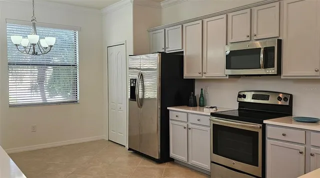 a kitchen with stainless steel appliances white cabinets and a stove top oven