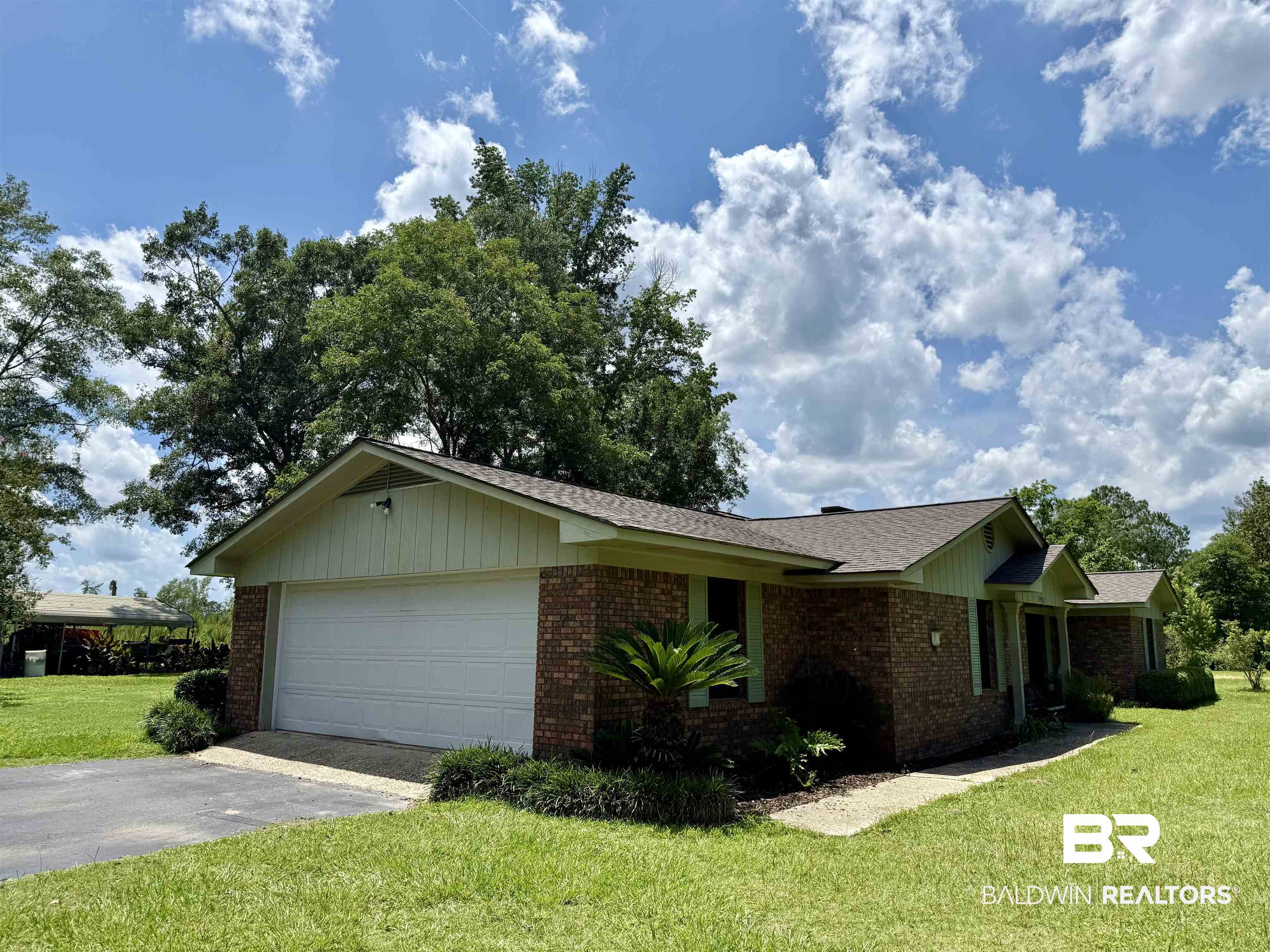 5971 Appleton Road Brewton, AL 36426 - Photo 19 of 23 View of front of property featuring a garage, brick siding, asphalt driveway, and a front lawn