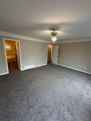 wooden floor in an empty room with a chandelier