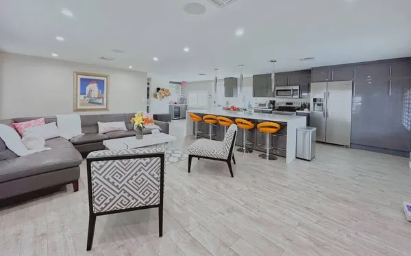 a living room with furniture and kitchen view