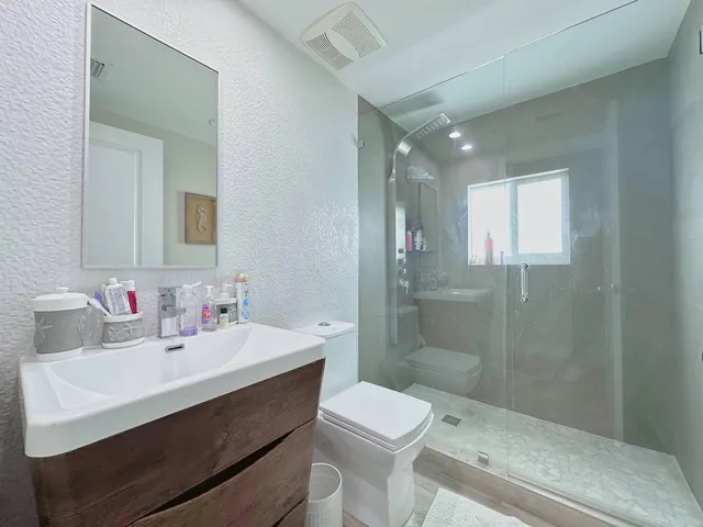 a bathroom with a sink toilet vanity and shower