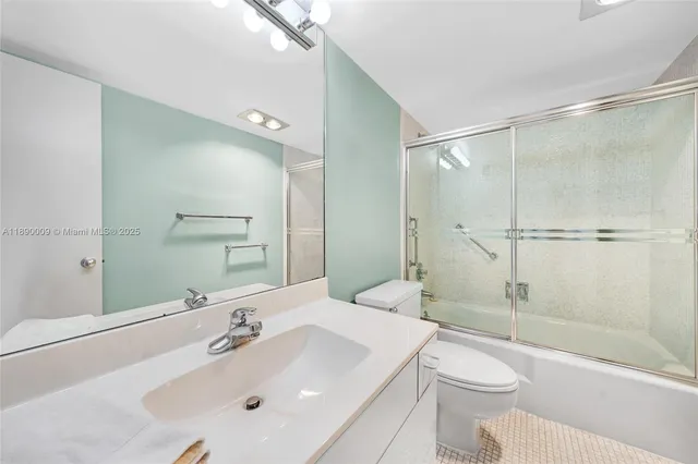 a bathroom with a sink mirror shower and a toilet