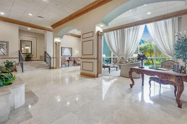a living room with furniture a large window and stainless steel appliances