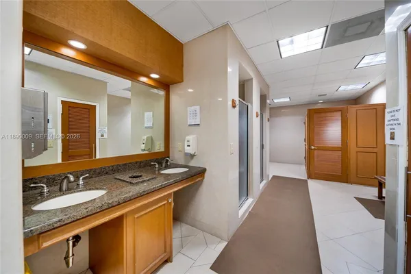 a bathroom with a granite countertop sink and a mirror