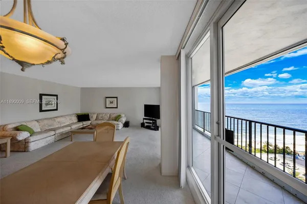 a living room with furniture a flat screen tv and a floor to ceiling window