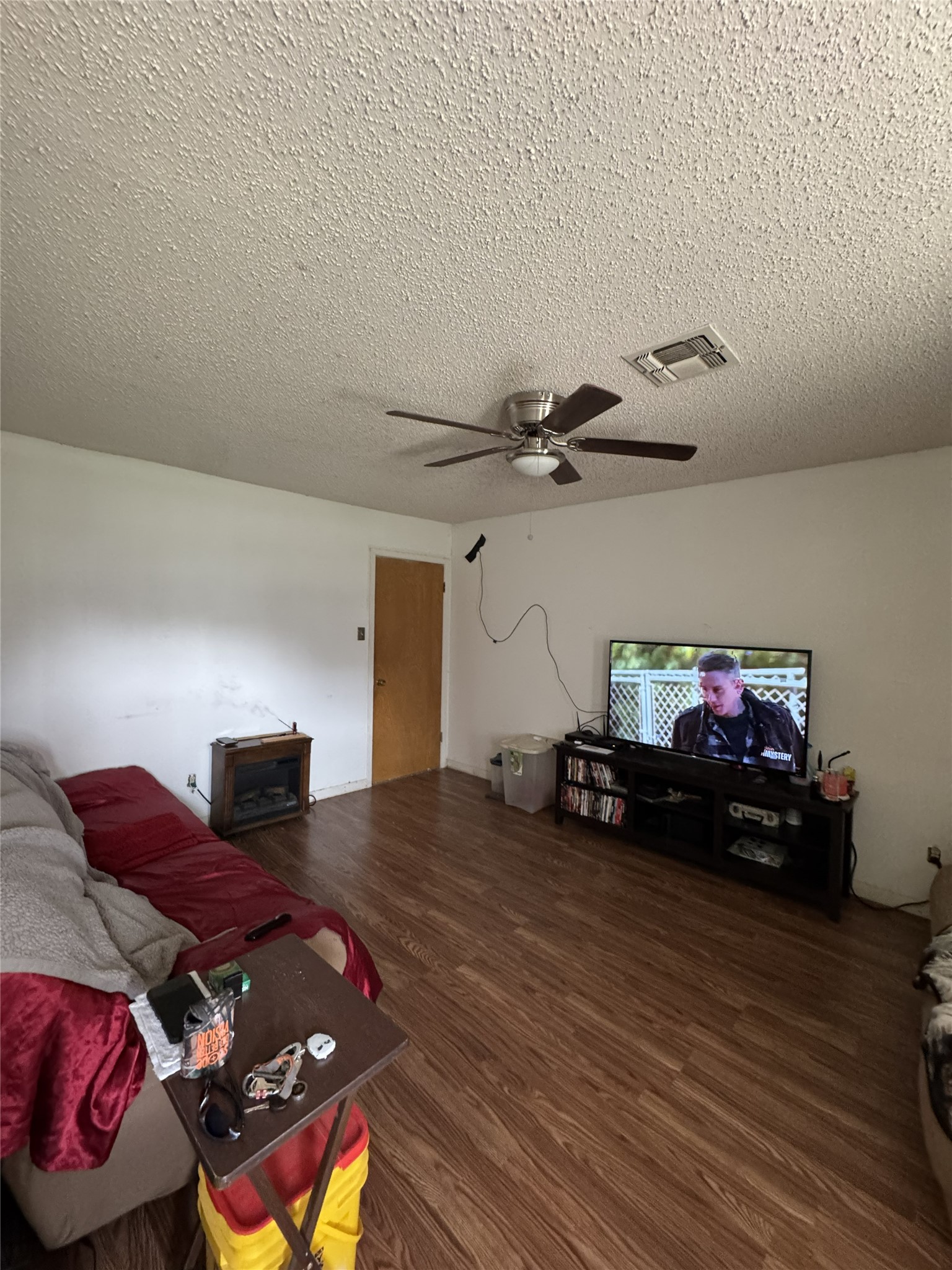 106 North 7th Street Dawson, TX 76639 - Photo 4 of 28 Living room with dark wood finished floors, ceiling fan, and a textured ceiling
