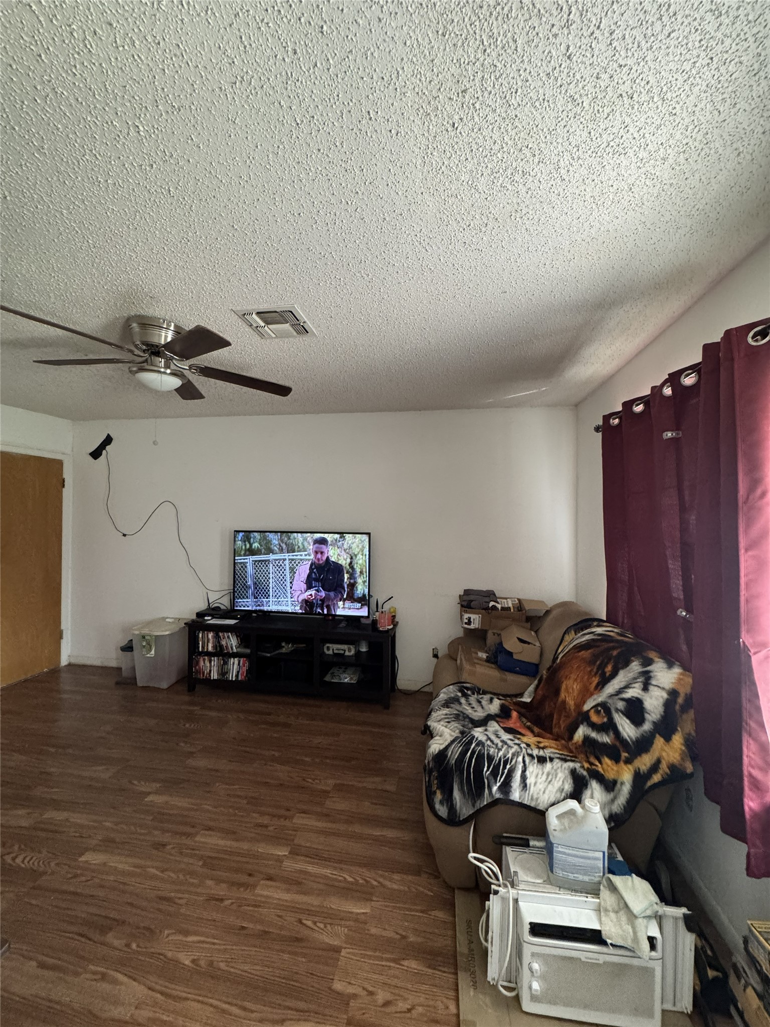 106 North 7th Street Dawson, TX 76639 - Photo 5 of 28 Living room with a textured ceiling, dark wood-style flooring, and a ceiling fan