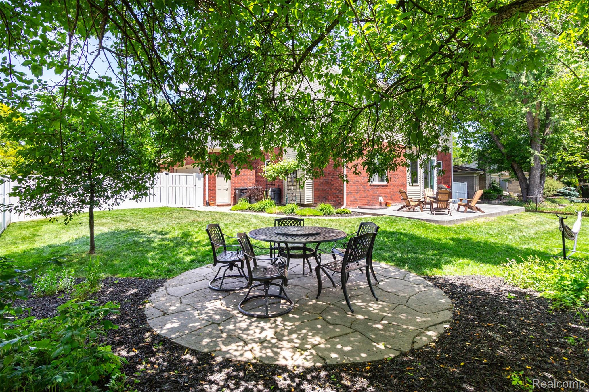 36039 Curtis Road Livonia, MI 48152 - Photo 52 of 61 Expansive backyard featuring a stone patio, a red brick exterior, and a secondary raised patio