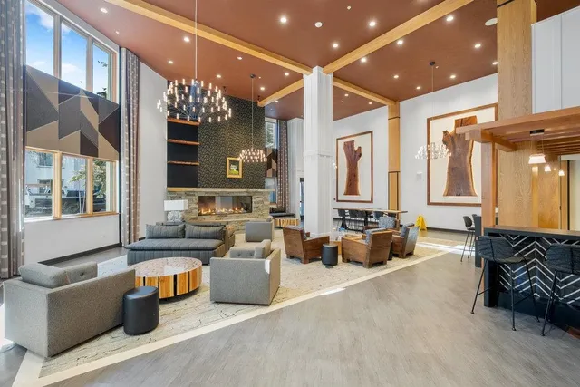 a living room with furniture a large window and wooden floor