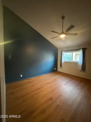 an empty room with windows and fan