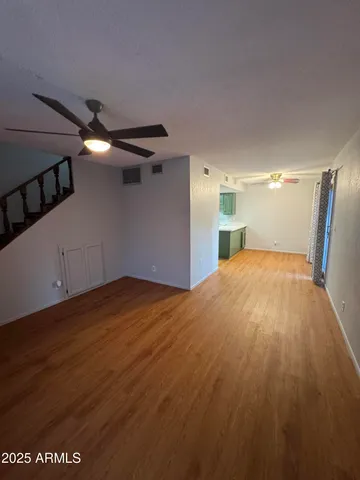 a view of empty room with wooden floor