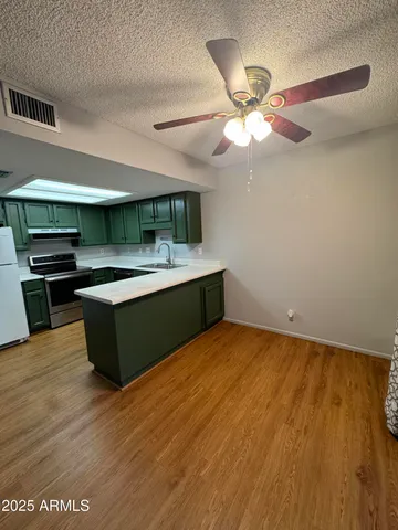 a room with kitchen island stainless steel appliances a stove and a bookshelf