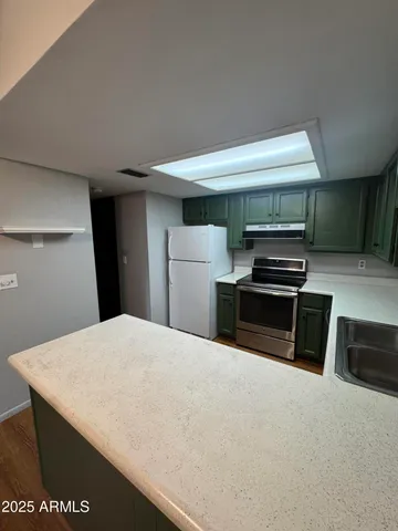 a kitchen with a refrigerator and a stove top oven