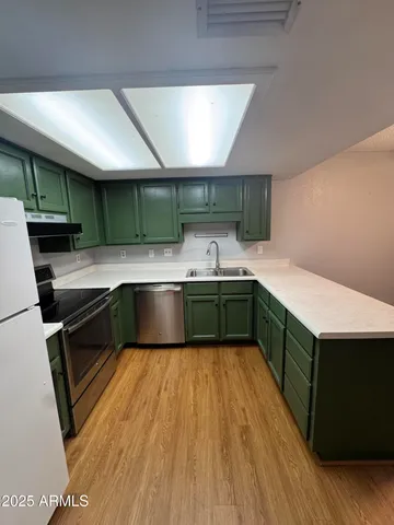 a kitchen with a sink cabinets and wooden floor