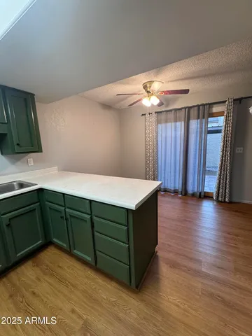 a kitchen with granite countertop a sink cabinets and wooden floor