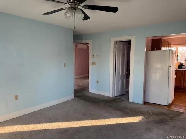 a view of a livingroom with a ceiling fan and refrigerator