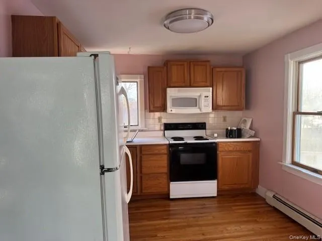 a kitchen with stainless steel appliances a refrigerator a stove a sink and a window