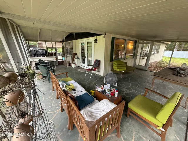 a living room with furniture and a floor to ceiling window