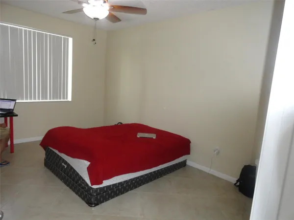 a room with a bed and a chandelier fan