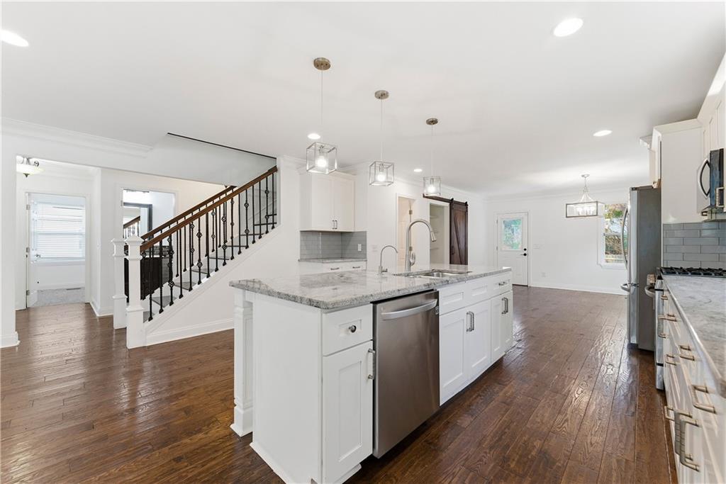 1779 North Olympian Way Southwest Atlanta, GA 30310 - Photo 11 of 48 a kitchen with granite countertop a stove and a wooden floor