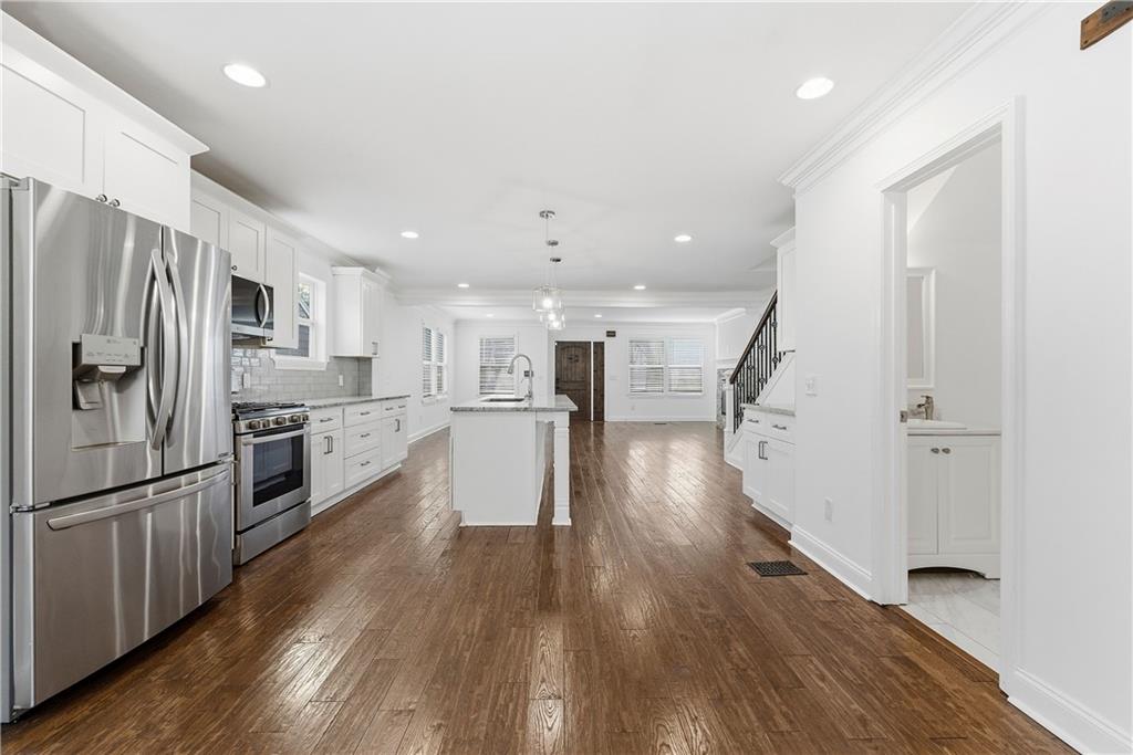 1779 North Olympian Way Southwest Atlanta, GA 30310 - Photo 12 of 48 a view of a kitchen center island wooden floor stainless steel appliances and cabinets