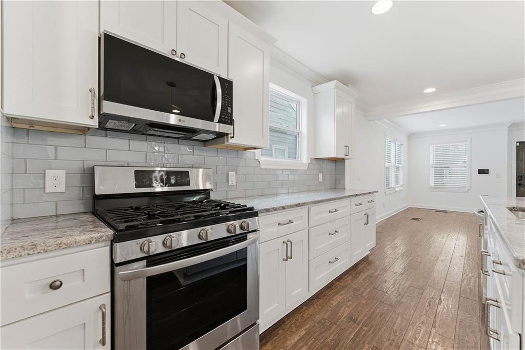 1779 North Olympian Way Southwest Atlanta, GA 30310 - Photo 13 of 48 a kitchen with stainless steel appliances granite countertop a stove and a microwave