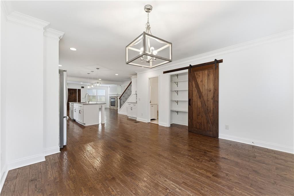 1779 North Olympian Way Southwest Atlanta, GA 30310 - Photo 16 of 48 a view of a room with wooden floor staircase and a kitchen