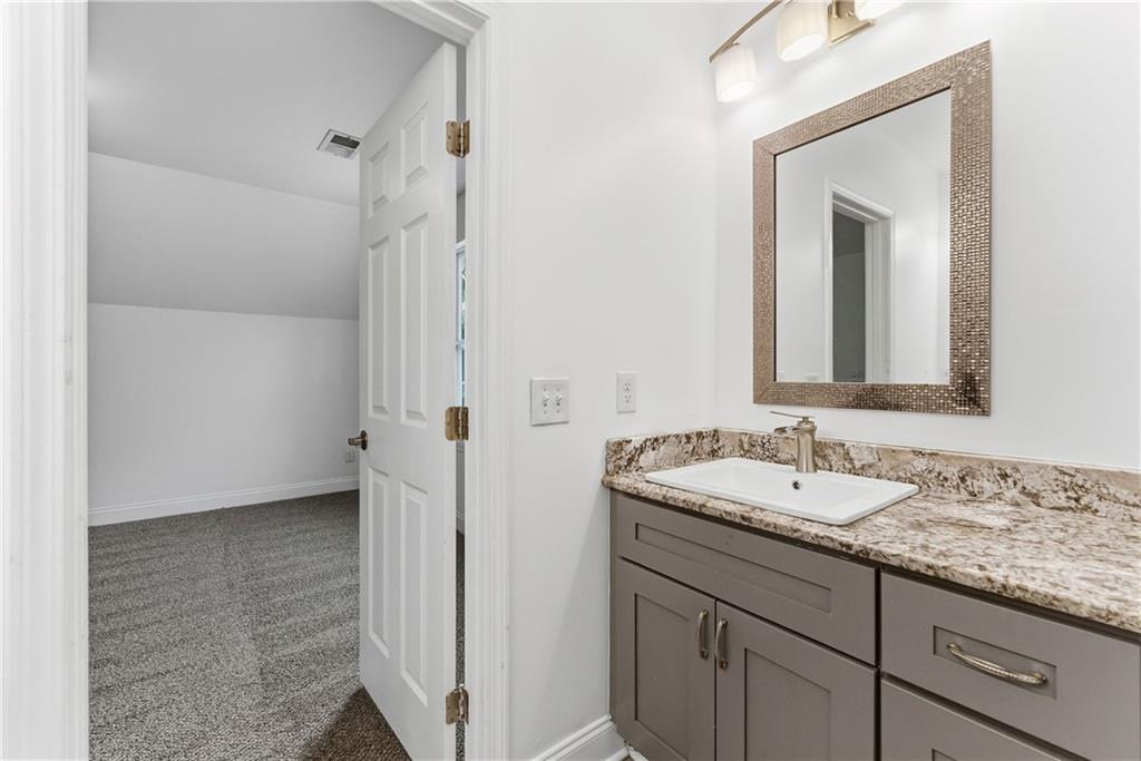 1779 North Olympian Way Southwest Atlanta, GA 30310 - Photo 31 of 48 a bathroom with a granite countertop sink mirror and vanity