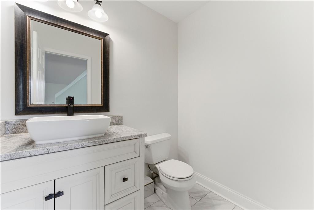 1779 North Olympian Way Southwest Atlanta, GA 30310 - Photo 41 of 48 a bathroom with a toilet a sink and mirror