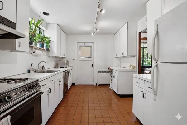 a kitchen with white cabinets and white appliances