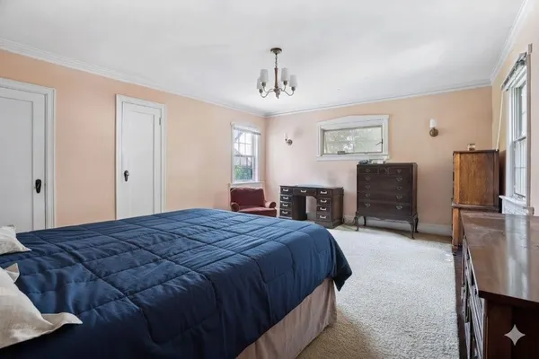 a spacious bedroom with a bed dresser and a flat tv screen