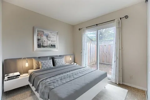 a bedroom with a balcony a bed and painting on the wall