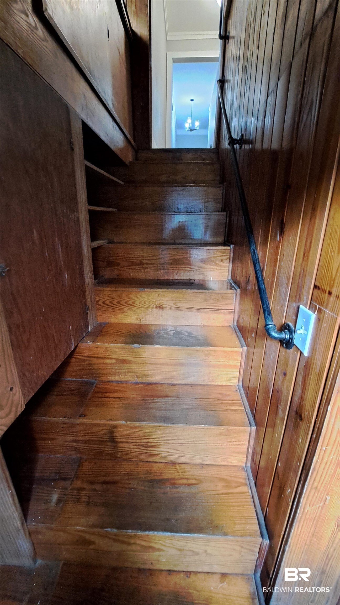 110 South Main Street Evergreen, AL 36401 - Photo 19 of 27 Wood-finish staircase with paneling and a dark metal handrail