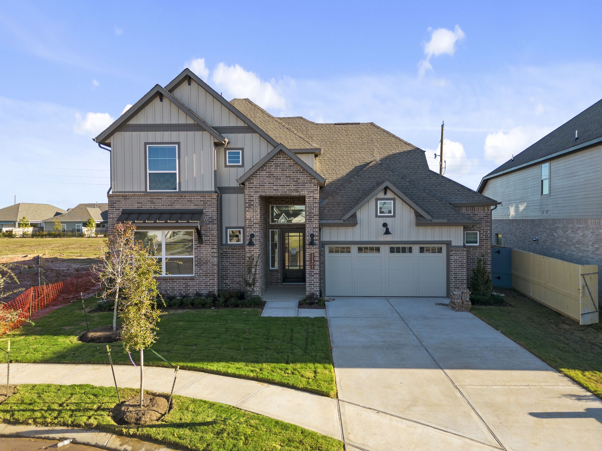 a front view of a house with a yard and potted plants