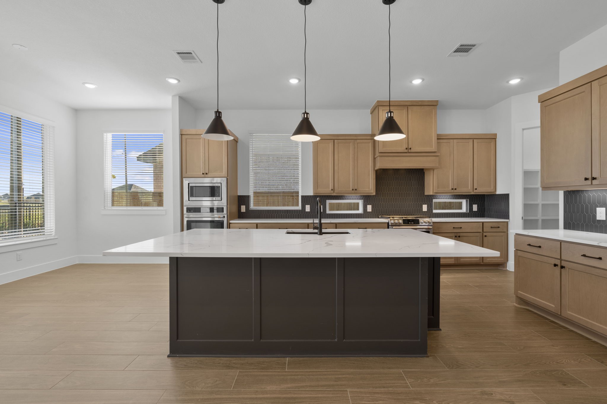 407 Blue River Trail Rosenberg, TX 77471 - Photo 23 of 45 a kitchen with stainless steel appliances granite countertop a sink a stove and a wooden floor