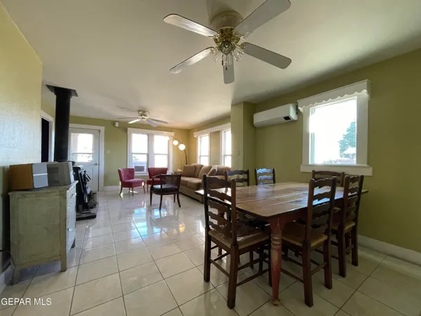 a view of a dining room and livingroom with furniture a rug a chandelier and window