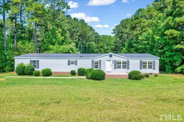 a front view of a house with a yard and trees