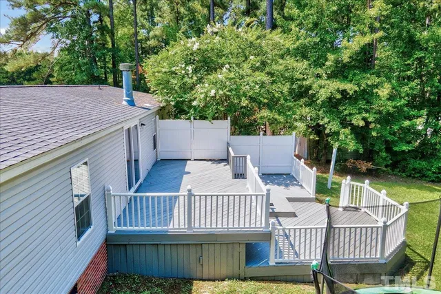 a view of a deck with furniture and a backyard