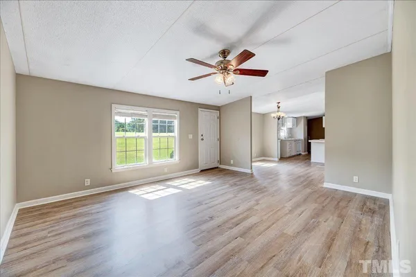 a view of a livingroom with wooden floor and a ceiling fan
