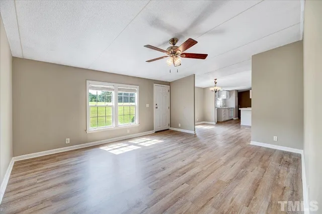 a view of a livingroom with wooden floor and a ceiling fan