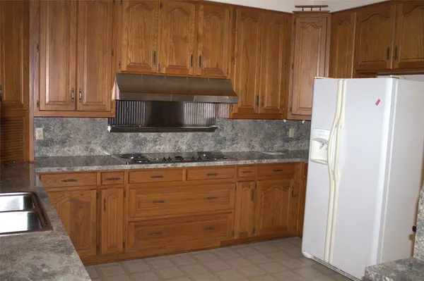 a kitchen with granite countertop wood cabinets and stainless steel appliances