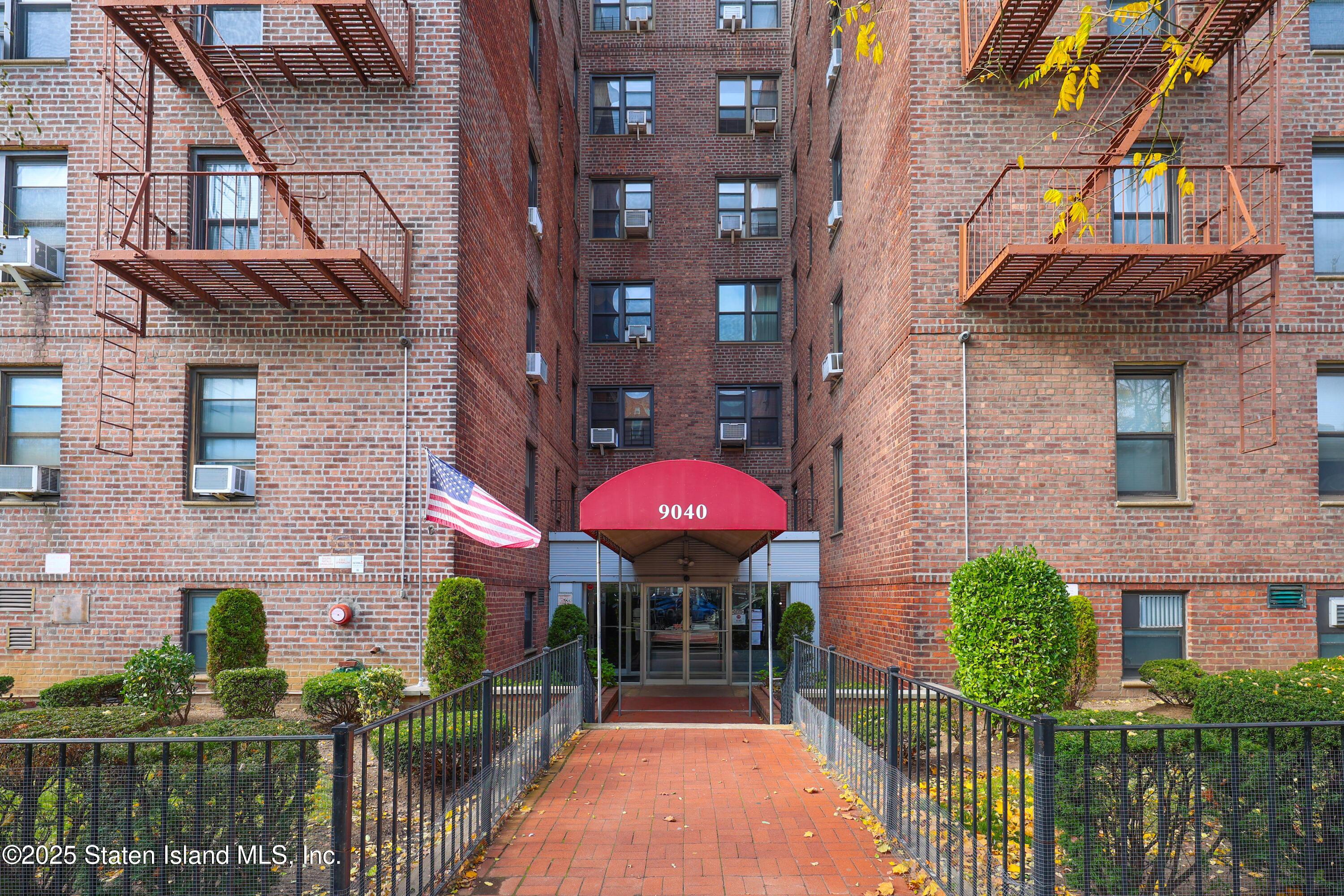 9040 Fort Hamilton Parkway, Unit 6C Brooklyn, NY 11209 - Photo 1 of 18 a front view of a brick building with glass windows and a table