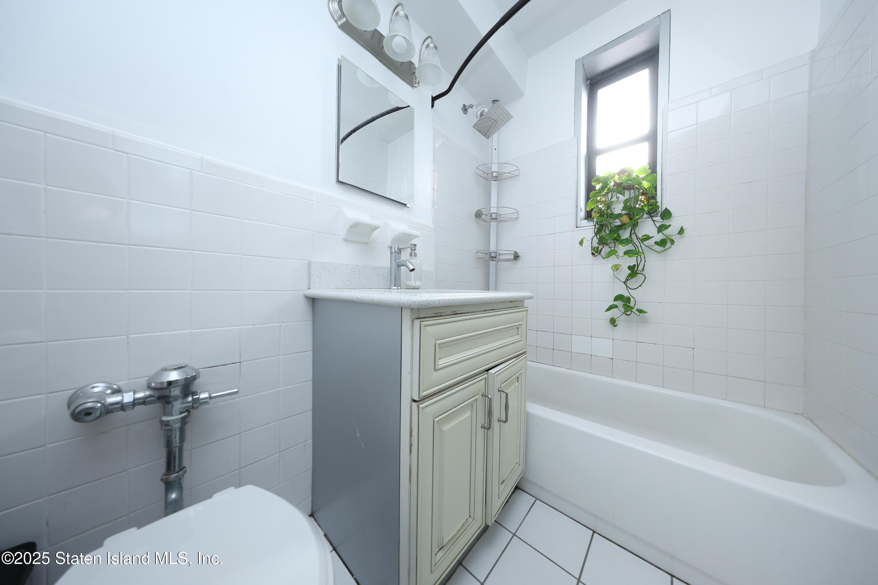 9040 Fort Hamilton Parkway, Unit 6C Brooklyn, NY 11209 - Photo 18 of 18 a bathroom with a sink a bathtub and a toilet