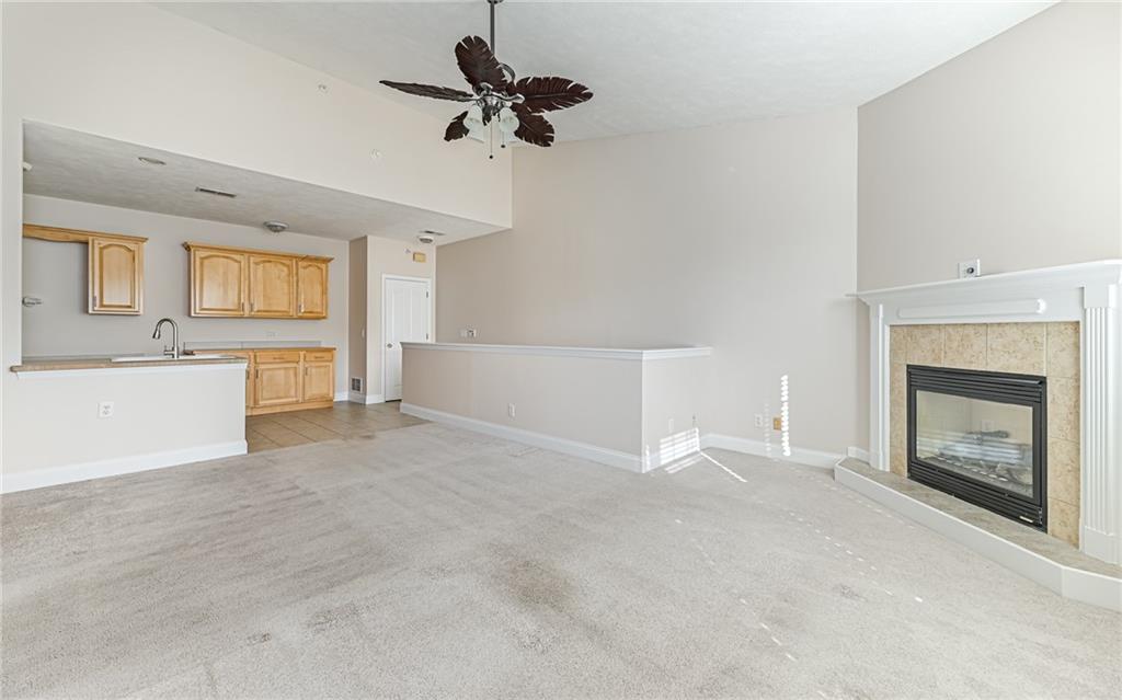 227 Adams Pointe Boulevard, Unit 3 Mars, PA 16046 - Photo 4 of 16 a view of a livingroom with a fireplace a ceiling fan and windows