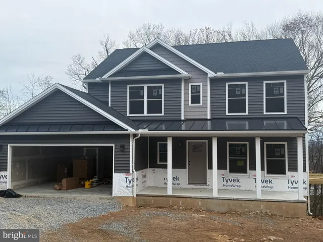 a front view of a house with a yard and parking space