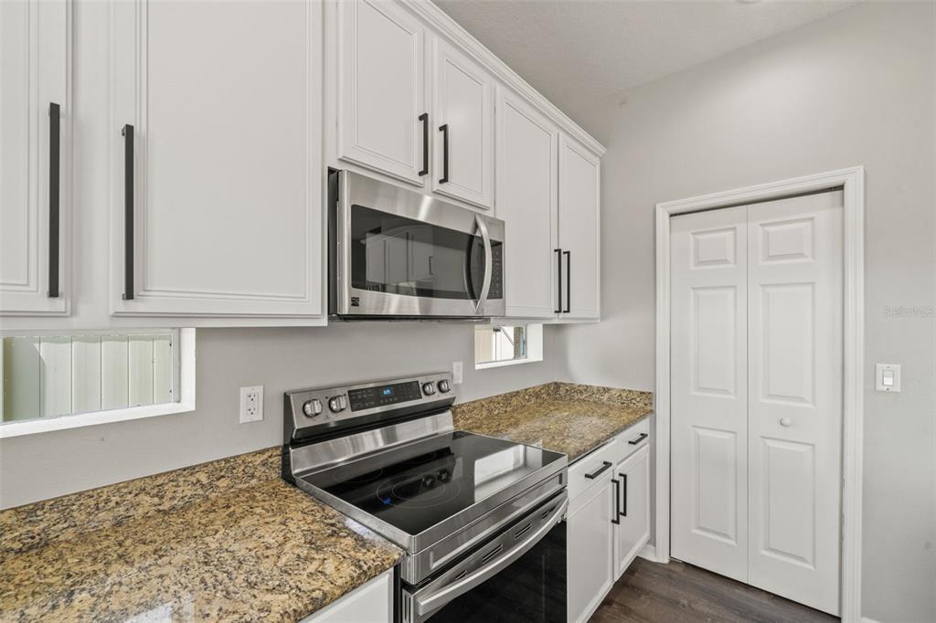 10909 Observatory Way Tampa, FL 33647 - Photo 11 of 39 a kitchen with white cabinets and black appliances