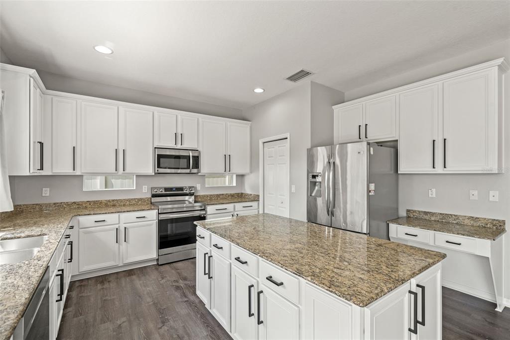 10909 Observatory Way Tampa, FL 33647 - Photo 12 of 39 a kitchen with stainless steel appliances granite countertop a stove top oven a refrigerator a sink and dishwasher with wooden floor